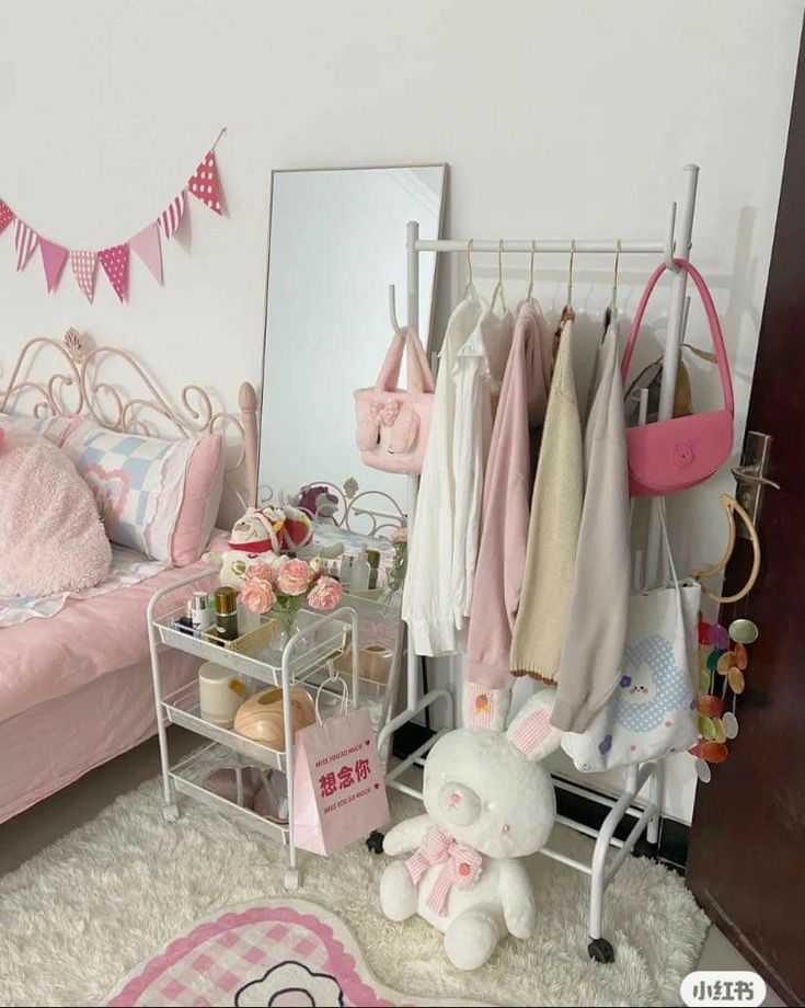 a pink and white bedroom with lots of clothes