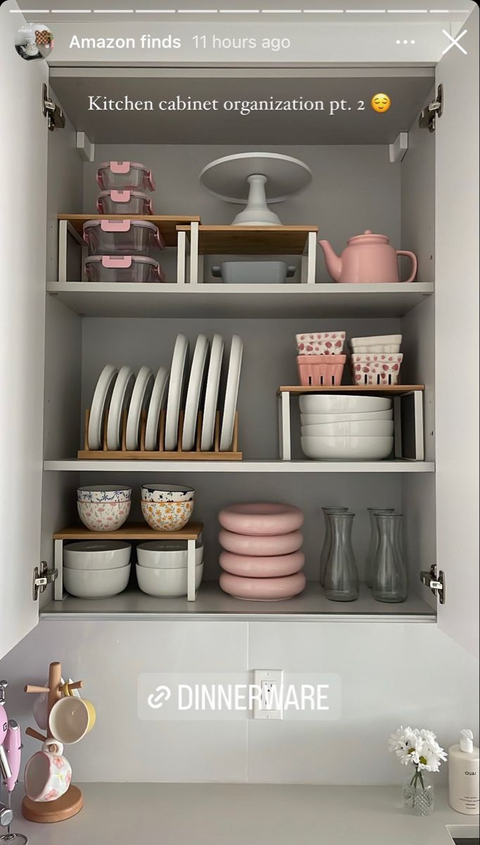 the shelves are filled with dishes and other kitchenware in pink, white and grey