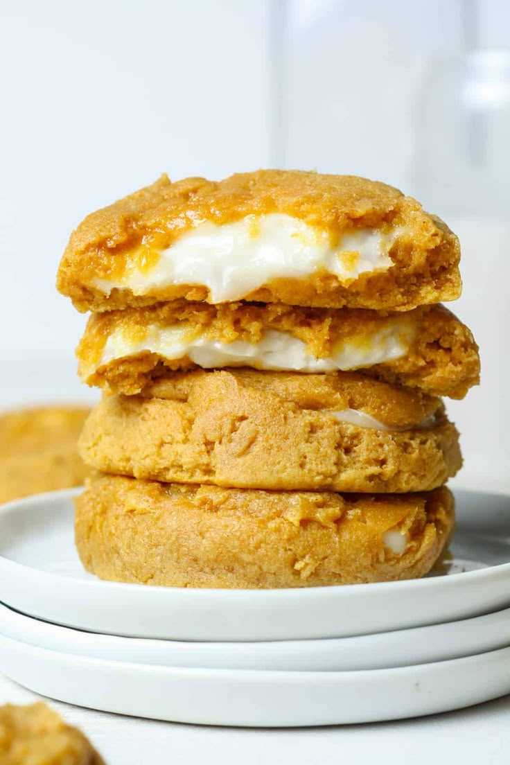 three cookies stacked on top of each other in front of a plate with one cookie