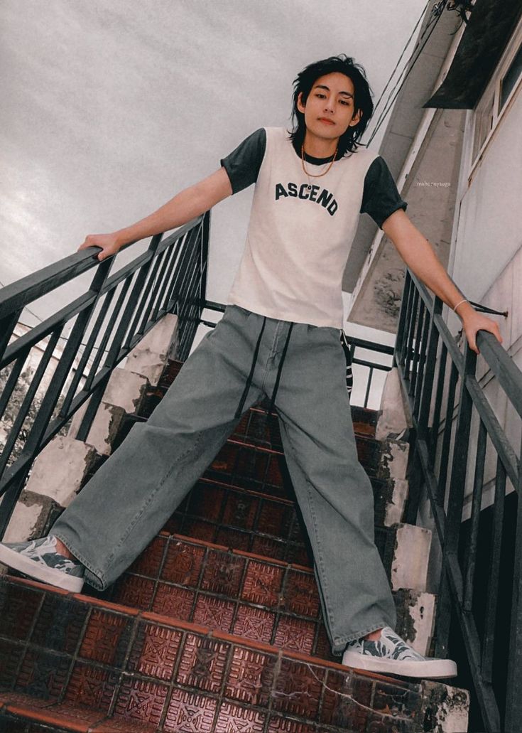 a young man standing on top of a stair case