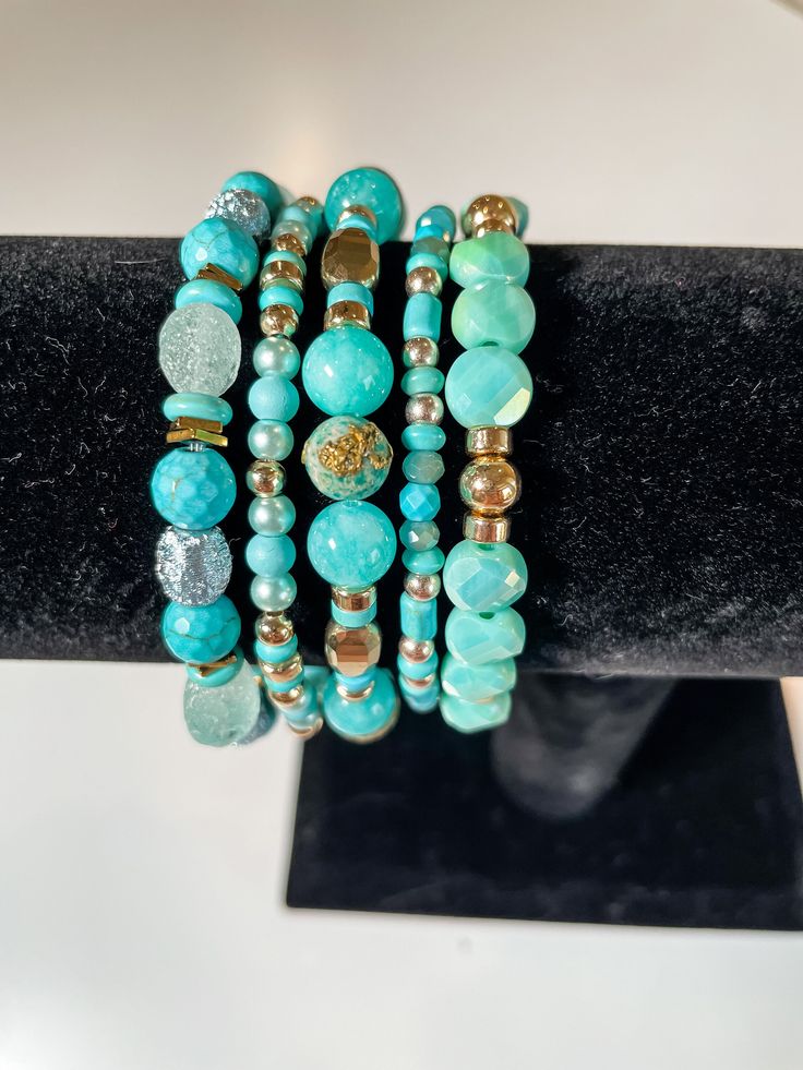 Handpicked Gems and Beads, Crafted into Stunning Stacks: Each piece is meticulously designed and handcrafted with love, ensuring that you receive truly unique and extraordinary accessories. These bracelets are carefully curated to showcase a harmonious blend of colors, textures, and styles. All bracelets are approximately 7.5 inches in length. This stack showcases gorgeous, eye-catching colors of turquoise and gold. Elevate your everyday style with this stunning bracelet stack.✨ #bracelets #jewelry #accessories #handmade #fashion #style #instajewelry #wristcandy #armcandy #jewelryaddict #fashionista #shopsmall #supportlocal #giftideas #braceletstacks #uniquebracelets #handcraftedjewelry #oneofakind #bohostyle #minimalistjewelry #statementjewelry #layeredlook #stackedbracelets #trendyjewelr Turquoise Wrap Bracelet With Round Beads As Gift, Elegant Turquoise Stretch Bracelet As Gift, Elegant Turquoise Stretch Bracelet As A Gift, Turquoise Stackable Bracelets As Gift, Unique Adjustable Turquoise Beaded Bracelet, Unique Turquoise Beaded Bracelets, Elegant Handmade Turquoise Beaded Bracelets, Turquoise Stackable Bangle Beaded Bracelets, Turquoise Stackable Beaded Bangle Bracelets