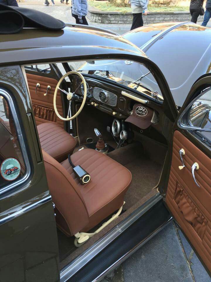 the interior of an old car with brown leather seats and steering wheel, as well as other classic cars