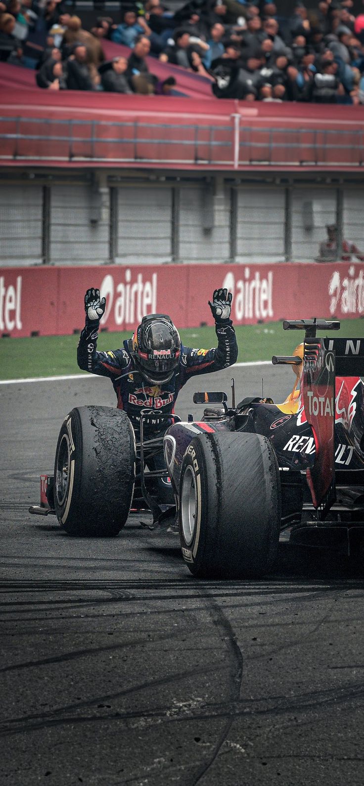 two red bull racing cars in front of an audience