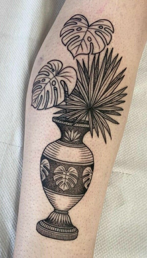 a black and white vase with plants in it