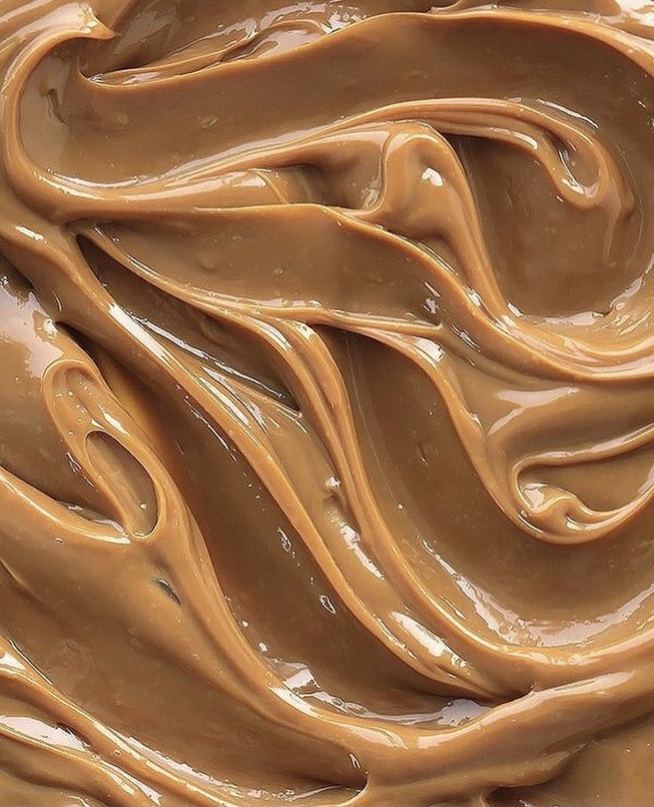 a white bowl filled with chocolate frosting on top of a table