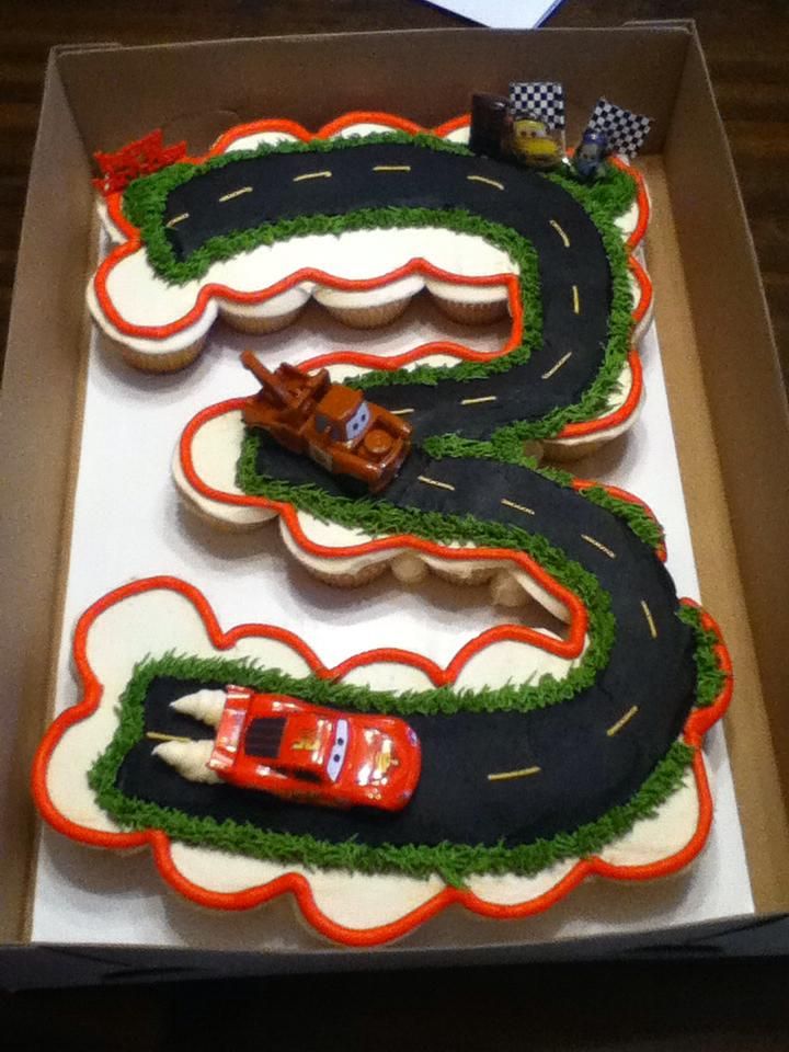 a cake in the shape of a road with cars on it