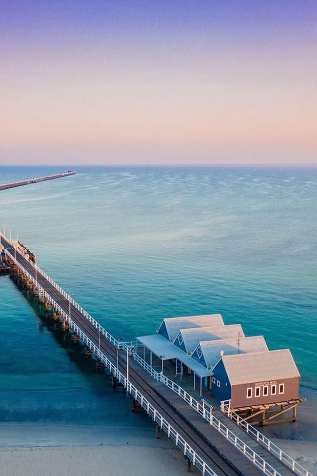 an aerial view of a pier in the middle of the ocean with houses on it