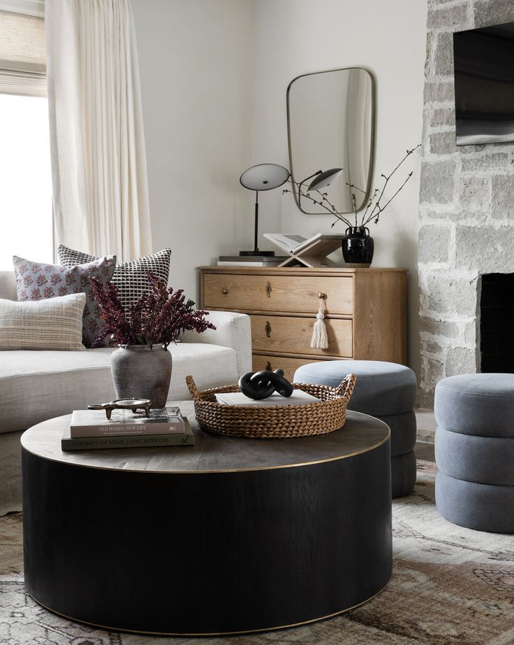 a living room filled with furniture and a fire place next to a window in front of a fireplace