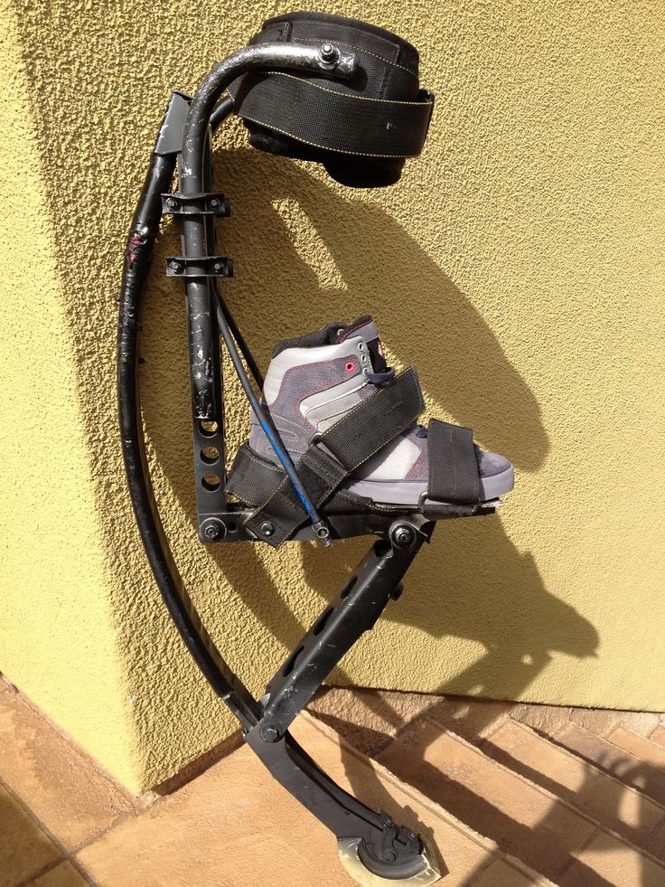 a pair of skis is propped up against a wall with a helmet on it