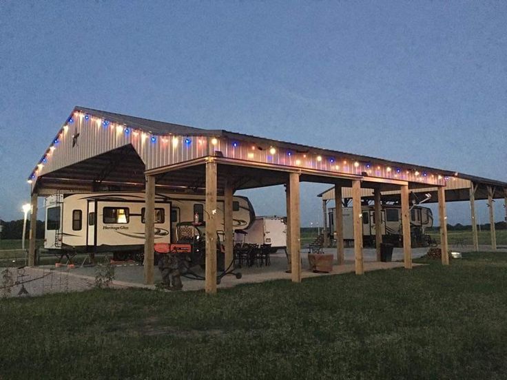 an rv is parked under a covered structure with lights on it's roof,