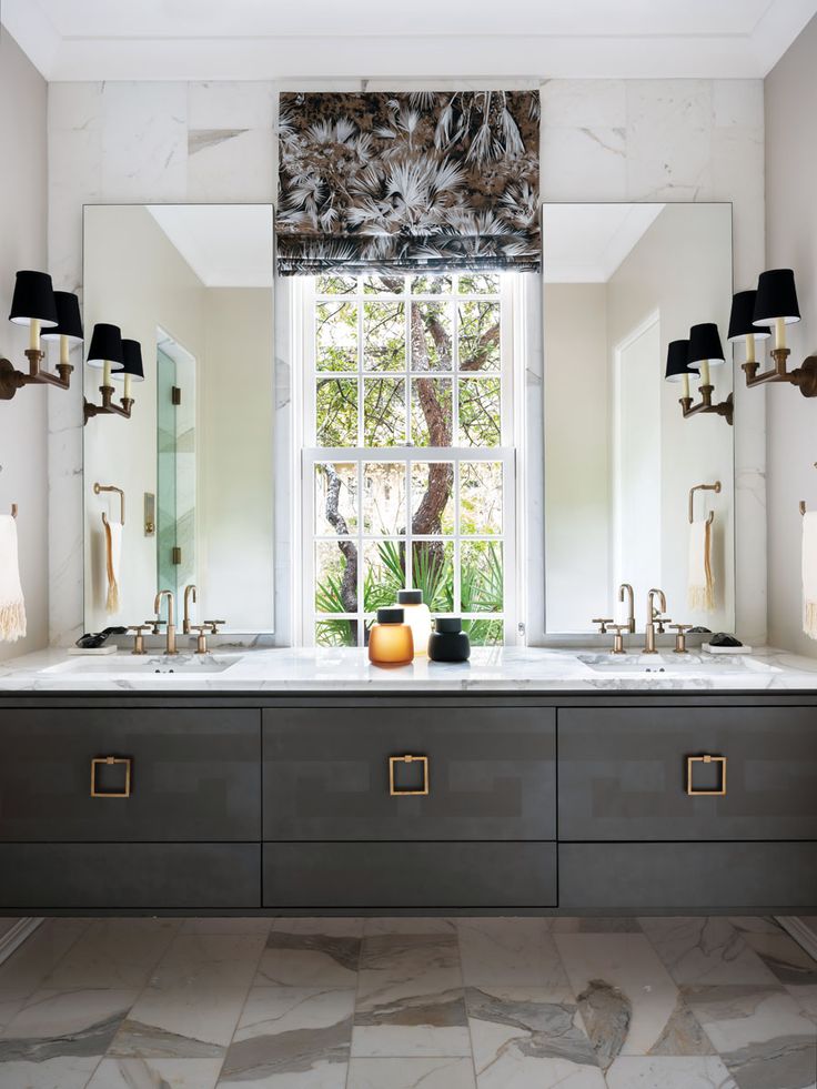 a bathroom with two sinks and mirrors in front of a large window that looks out onto the outdoors