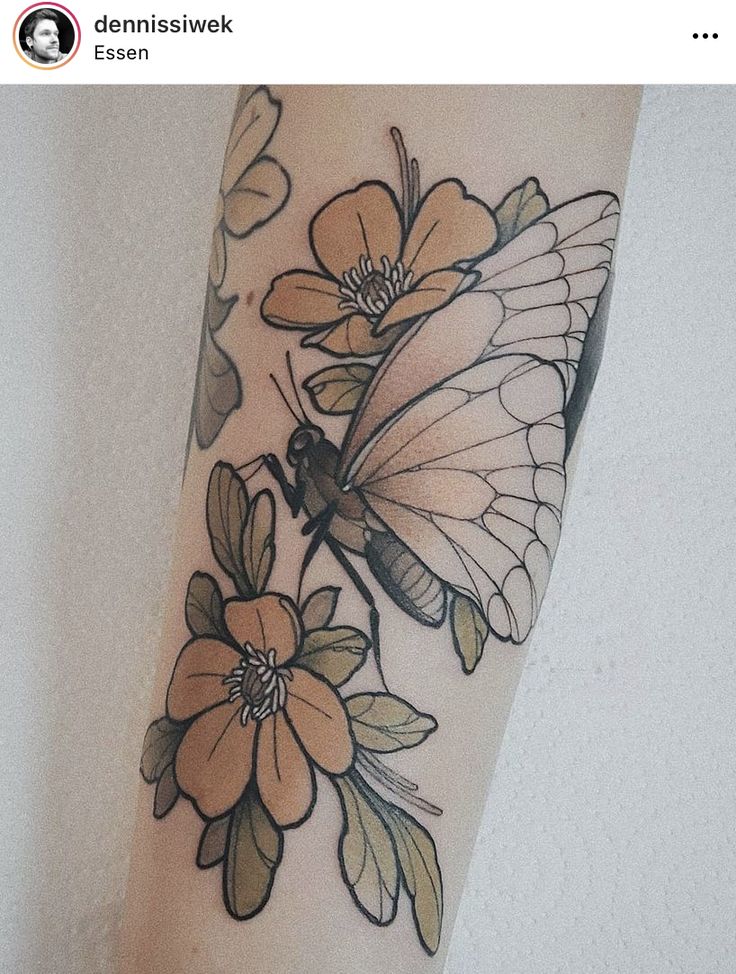 a butterfly and flower tattoo on the arm with white flowers around it's wings