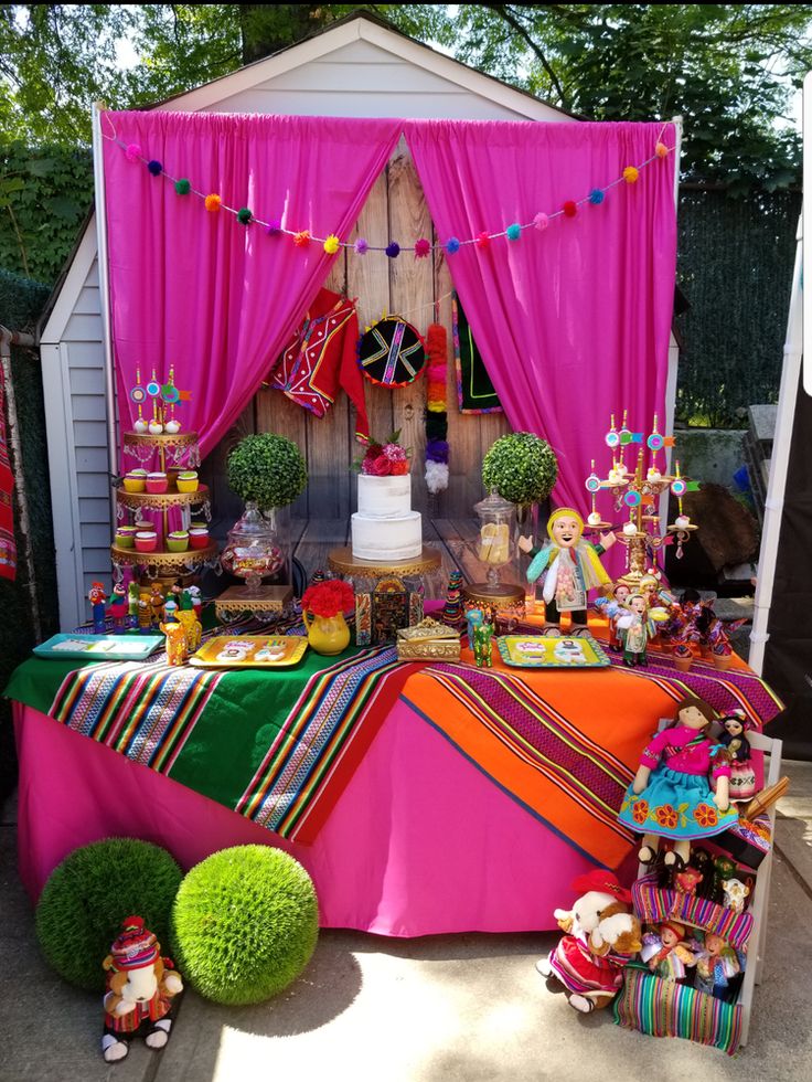 a table with many items on it in front of a tent and some decorations around it