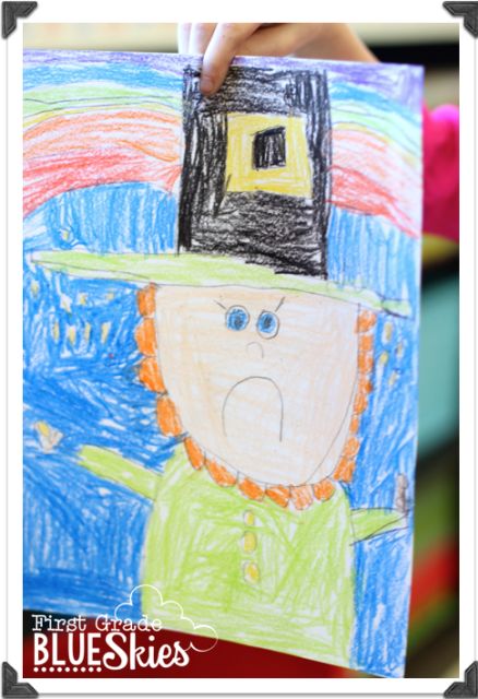 a child's hand holding up a drawing of a man in a top hat