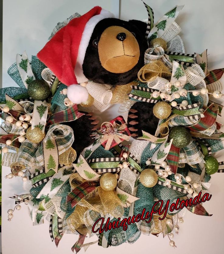 a christmas wreath with a teddy bear wearing a santa hat