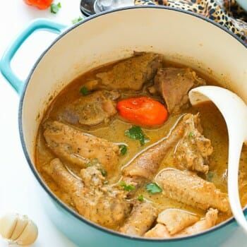 a blue pot filled with meat and vegetables