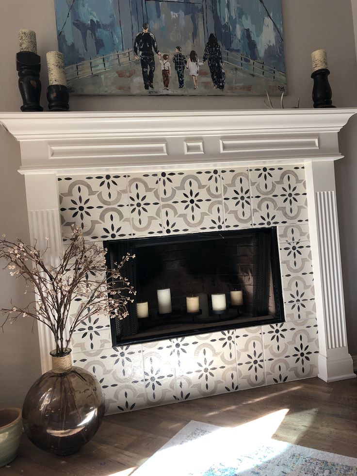 the fireplace is decorated with white flowers and candles in vases on top of it