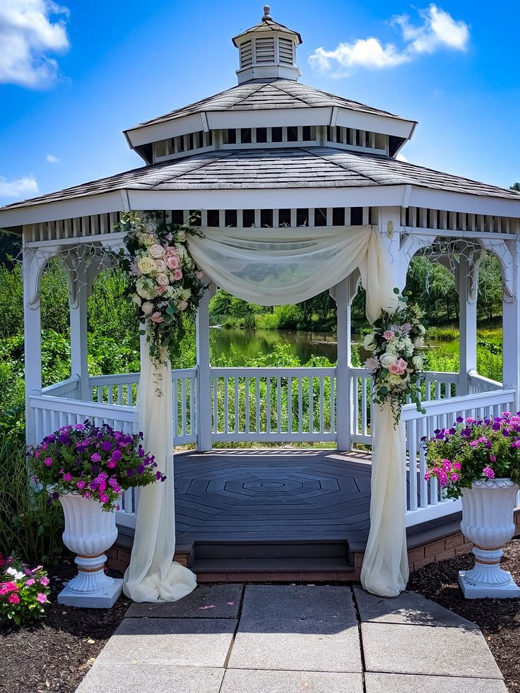 the gazebo is decorated with flowers and greenery