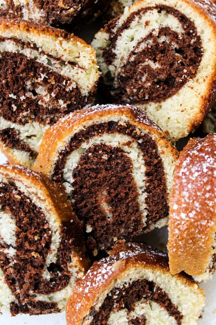 several pieces of cinnamon roll on a plate with powdered sugar sprinkled on top