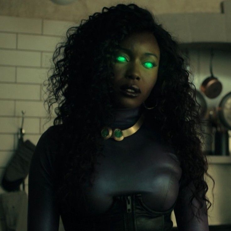 a woman with glowing green eyes standing in a kitchen