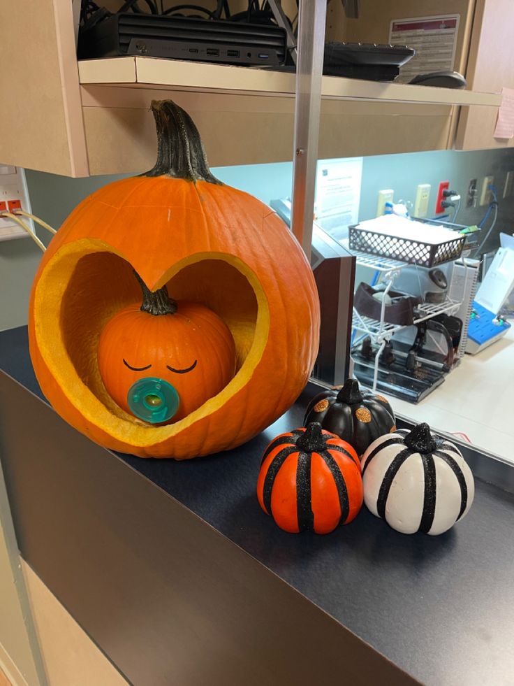 two pumpkins with faces carved into them sitting on a counter