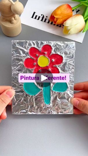 two hands holding a piece of tin foil with a flower on it and the words pintura essenntel