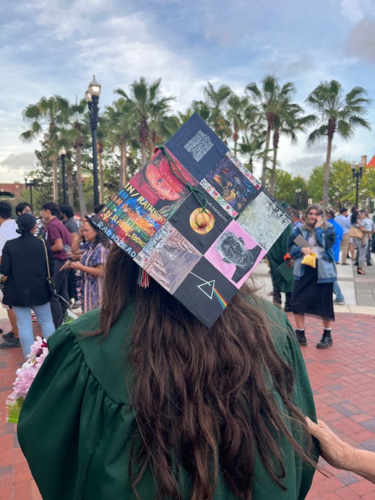 a person wearing a graduation cap with pictures on it's head and long hair