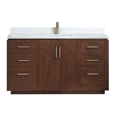 a bathroom vanity with a white counter top and brown wood cabinetry on the side