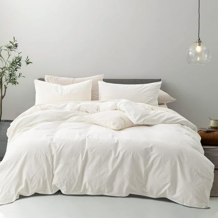 a bed with white linens and pillows in a minimalistic bedroom setting, with a plant next to the bed