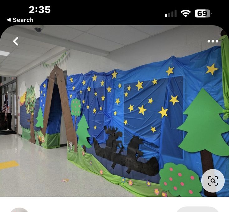 an image of a school hallway decorated with blue and green paper cutouts, trees and people in a sleigh