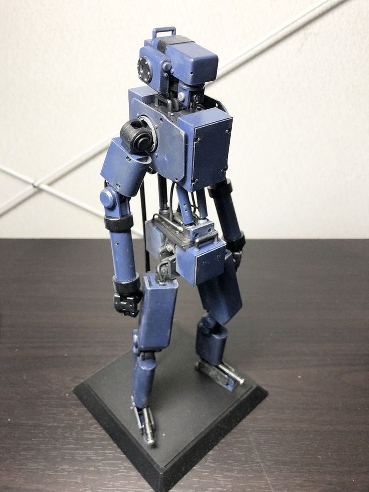 a blue robot standing on top of a wooden table