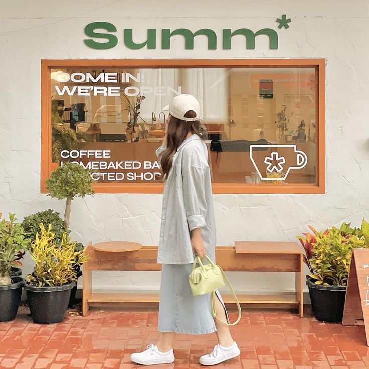 a woman standing in front of a store window