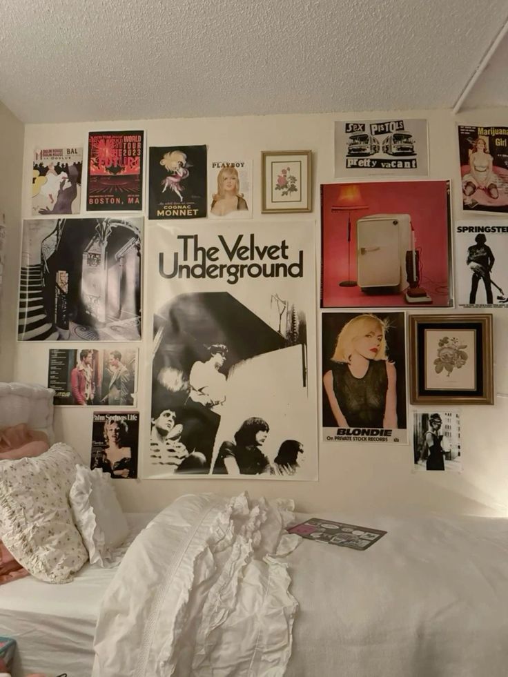 a bedroom with posters on the wall and bed