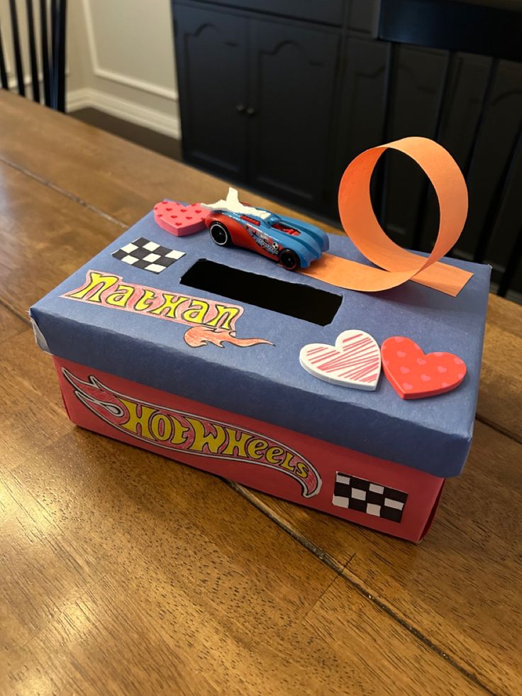 a cardboard box sitting on top of a wooden table covered in magnets and paper