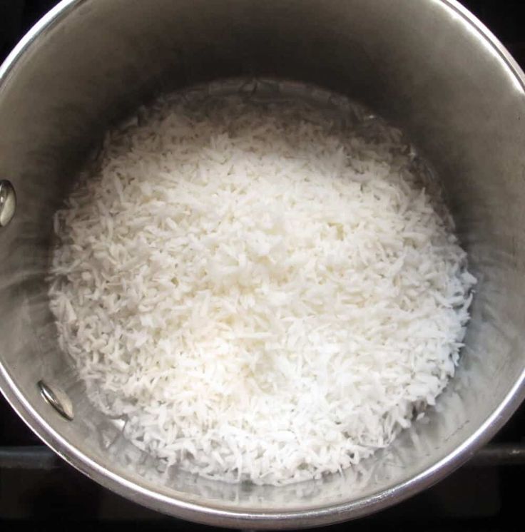 rice is being cooked in a pot on top of the stove, ready to cook