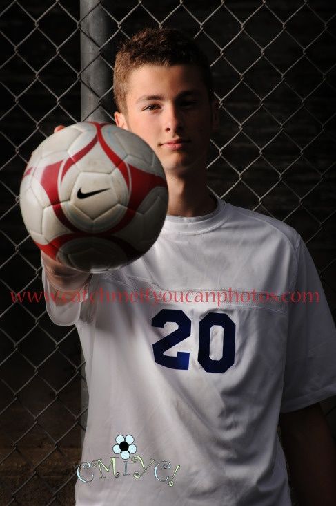 a young man holding a soccer ball in his hand