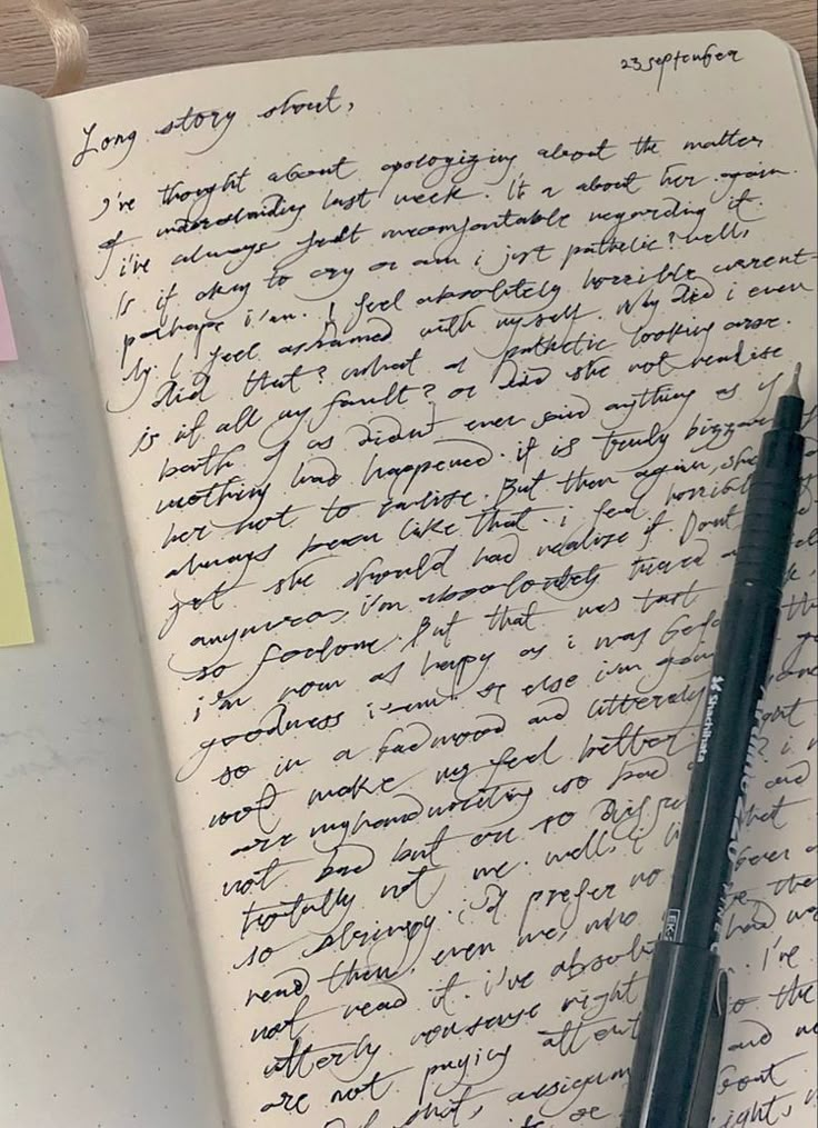 an open notebook with writing on it next to a pen