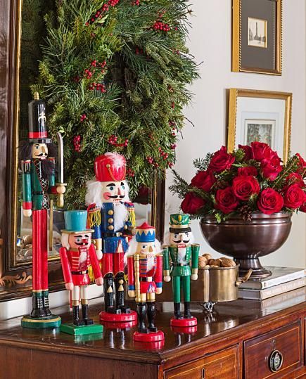 christmas decorations and nutcrackers sit on a dresser