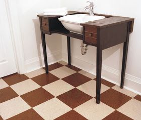 a bathroom sink sitting under a mirror on top of a tiled floor