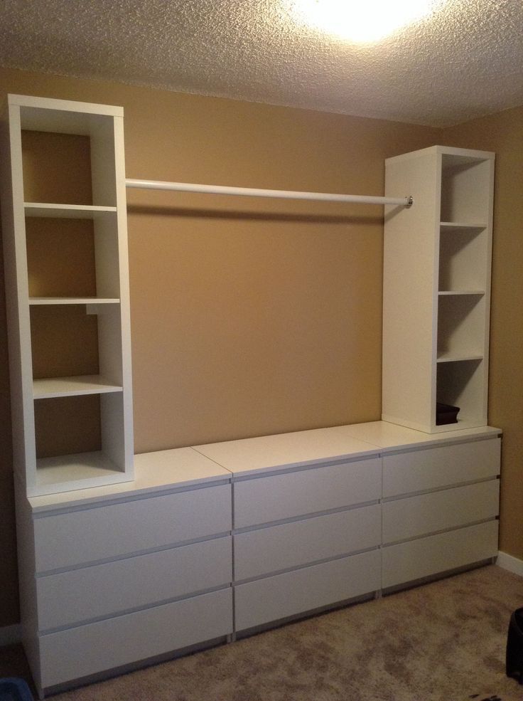 an empty room with white cabinets and shelves on the wall, in front of a carpeted floor