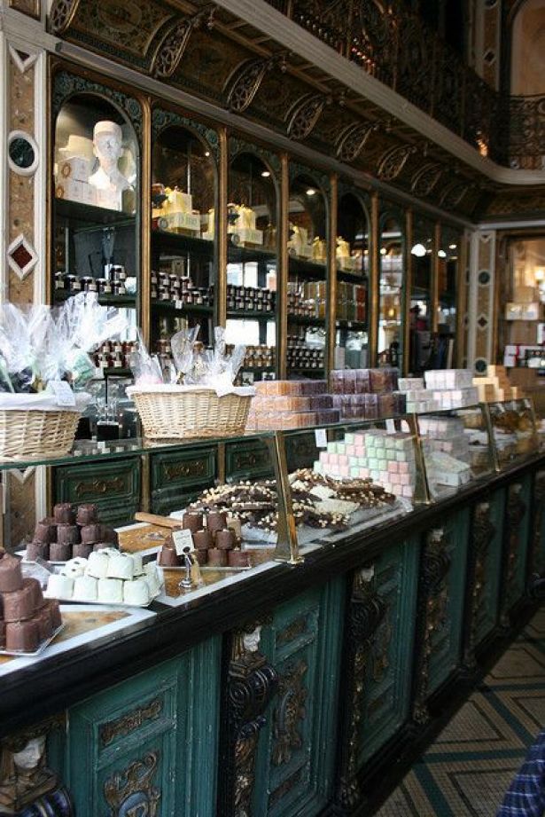 a store filled with lots of different types of cakes and pastries on display in front of the counter