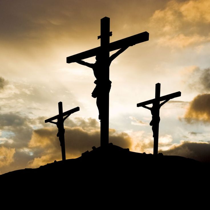 three crucifixs in silhouette against a cloudy sky