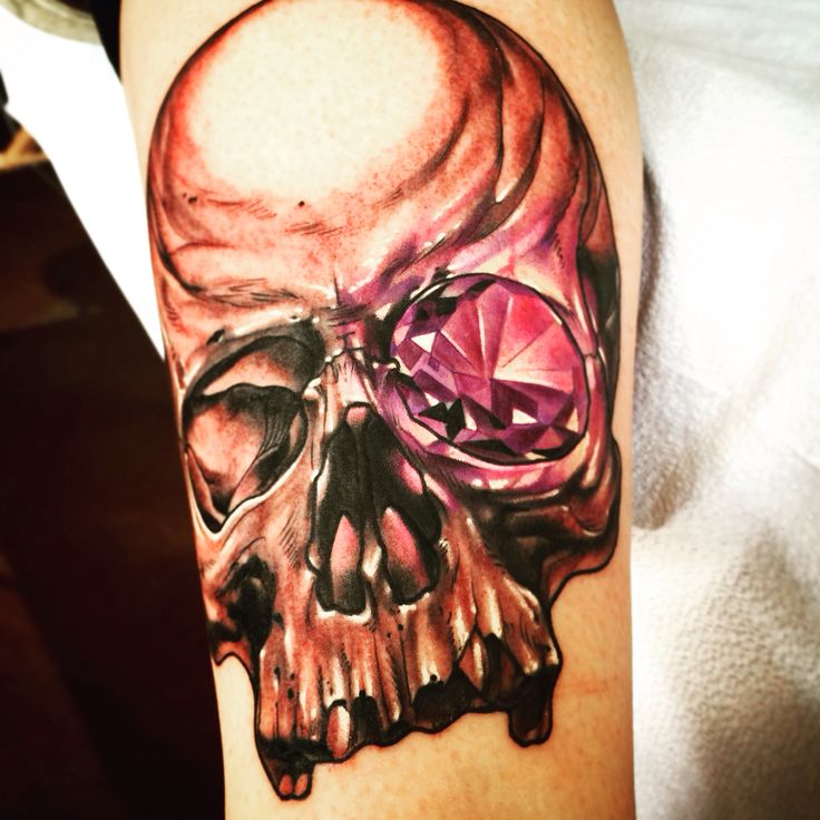 a skull with a pink diamond on it's head is shown in this tattoo