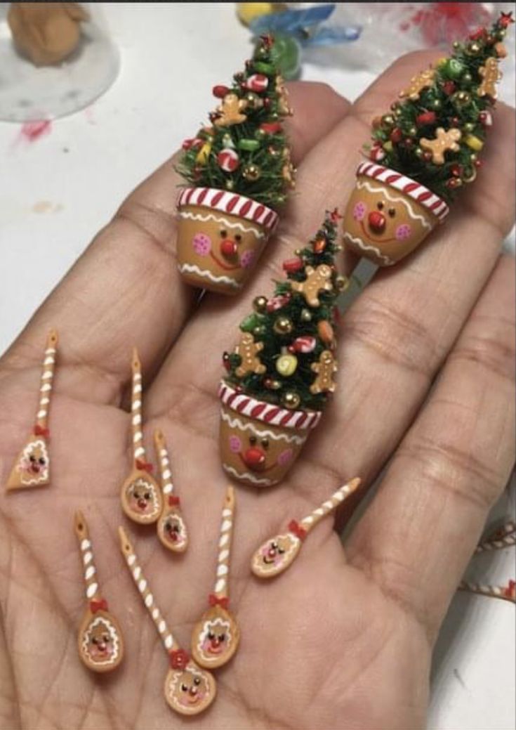 miniature christmas trees and ornaments in the palm of someone's hand