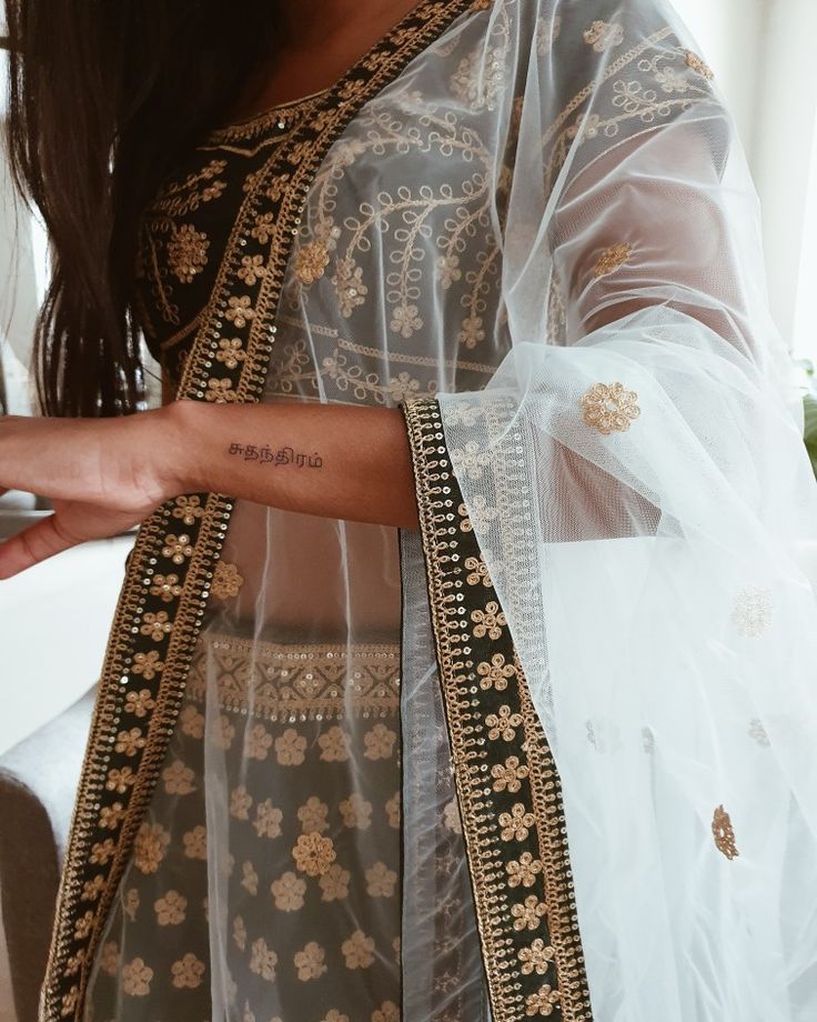 a woman wearing a white and gold sari