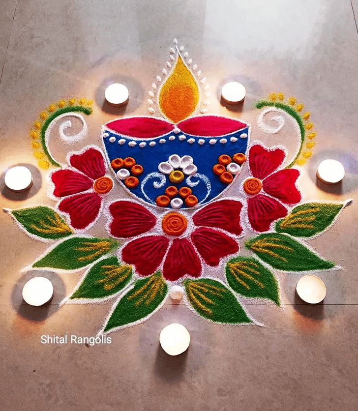 a decorated diya with candles on the floor