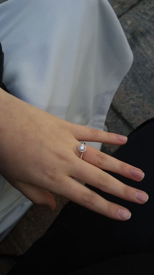 a close up of a person's hand with a diamond ring on their finger