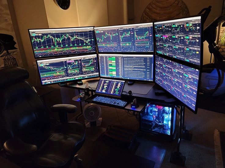 multiple computer monitors sitting on top of a desk