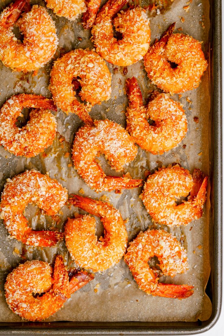 baked shrimp with parmesan cheese on top in a baking pan, ready to be served