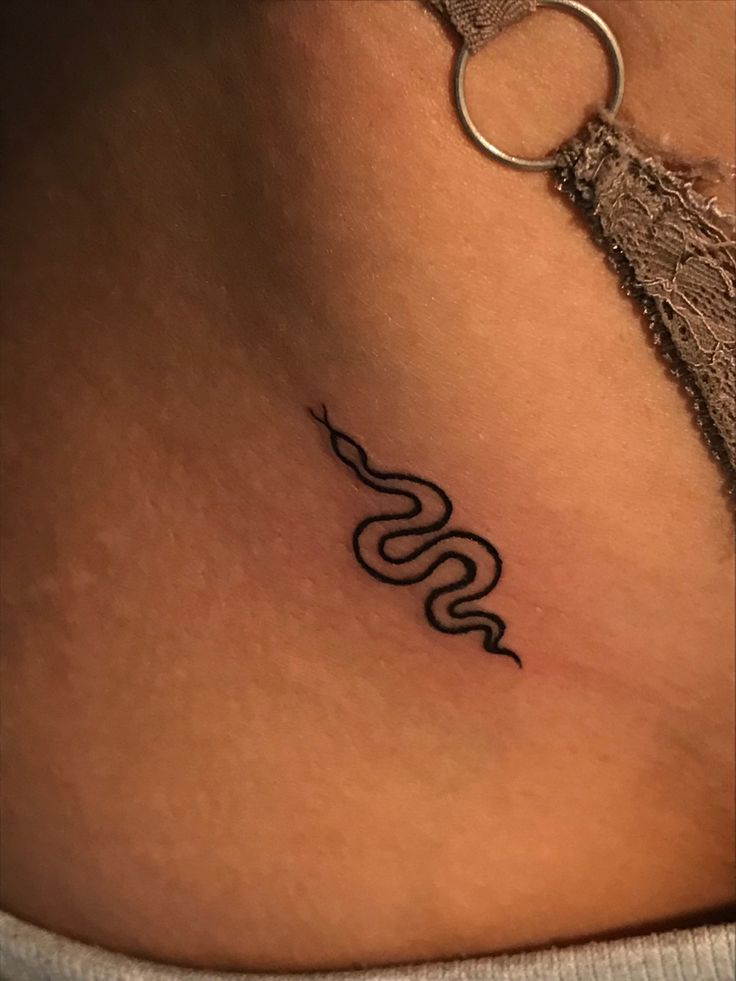 a woman's stomach with a snake tattoo on it